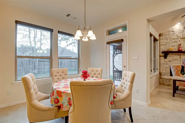 a dining room with furniture a chandelier and window