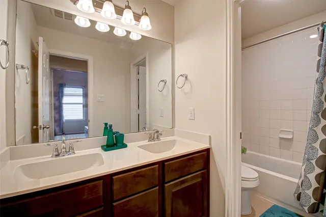 a bathroom with a sink a toilet and a large mirror
