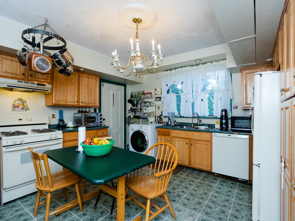 11 Rugdale Road Boston, MA 02124 - Photo 13 of 29 a kitchen with a dining table chairs and refrigerator
