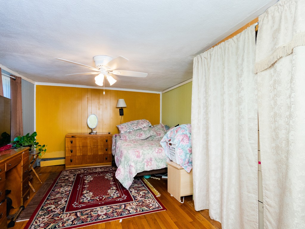 11 Rugdale Road Boston, MA 02124 - Photo 15 of 29 a bedroom with a bed and wooden floor
