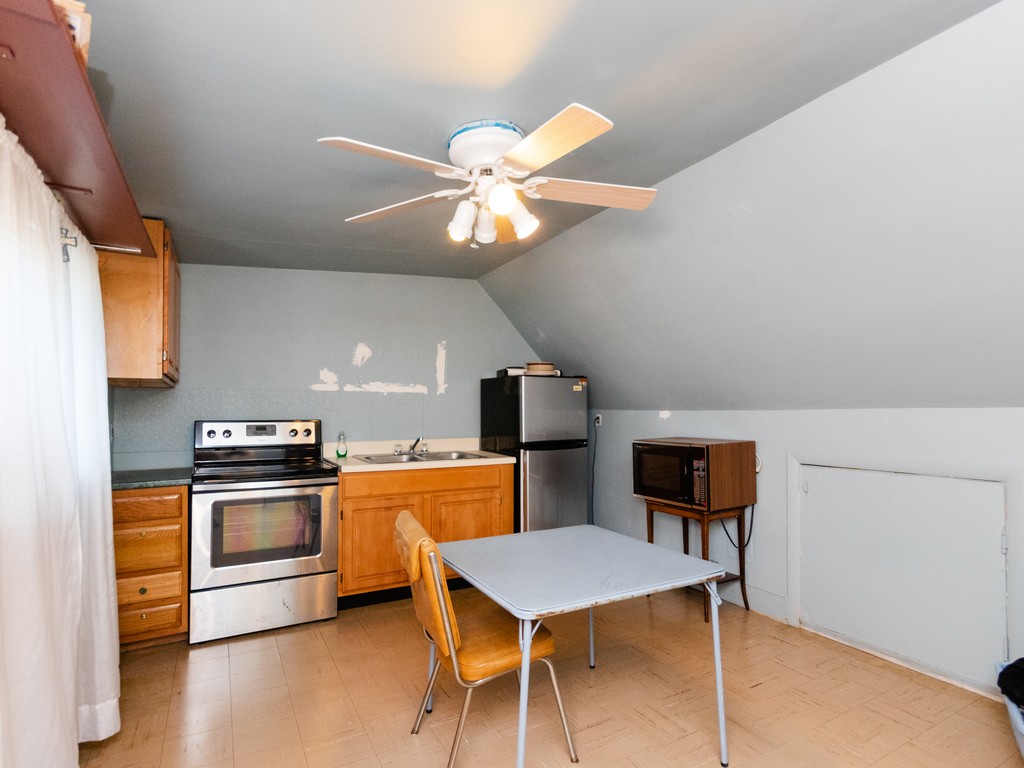 11 Rugdale Road Boston, MA 02124 - Photo 18 of 29 a kitchen with stainless steel appliances kitchen island a table and chairs in it