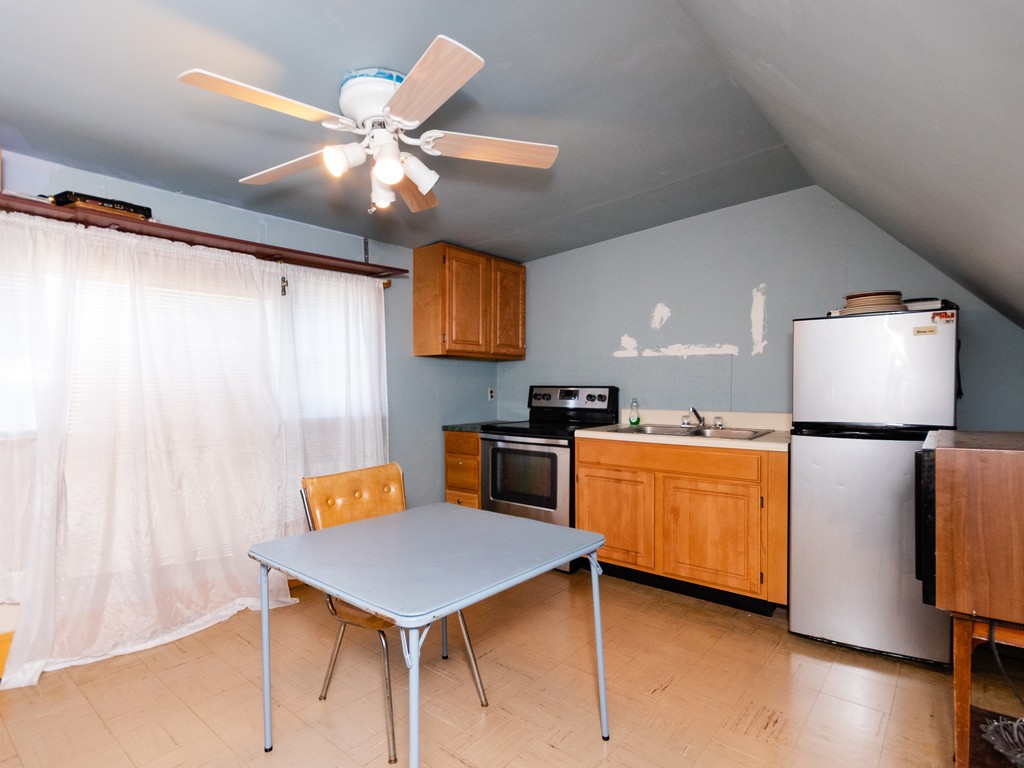 11 Rugdale Road Boston, MA 02124 - Photo 19 of 29 a kitchen with stainless steel appliances granite countertop a sink a stove top oven a chimney and a refrigerator