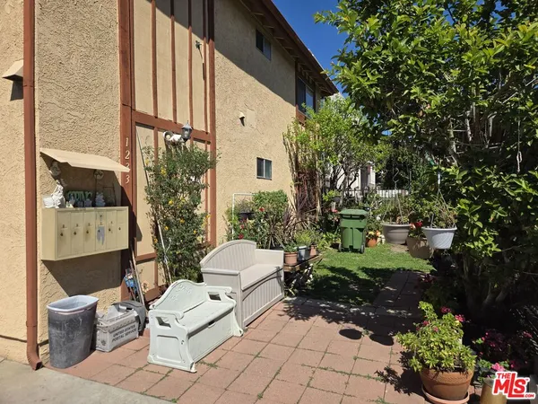 a view of a patio with chair and tables back yard of the house
