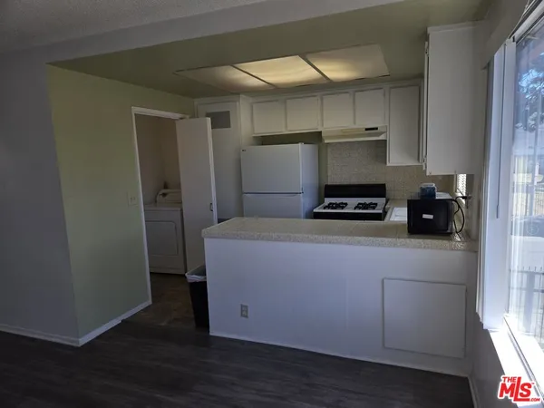 a kitchen with a refrigerator and a stove top oven