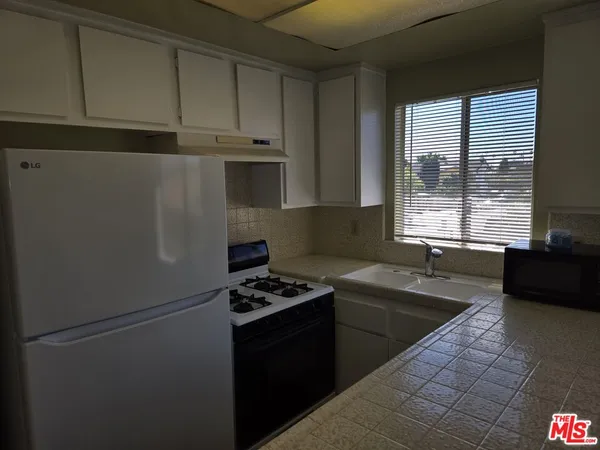 a kitchen with a refrigerator and a sink