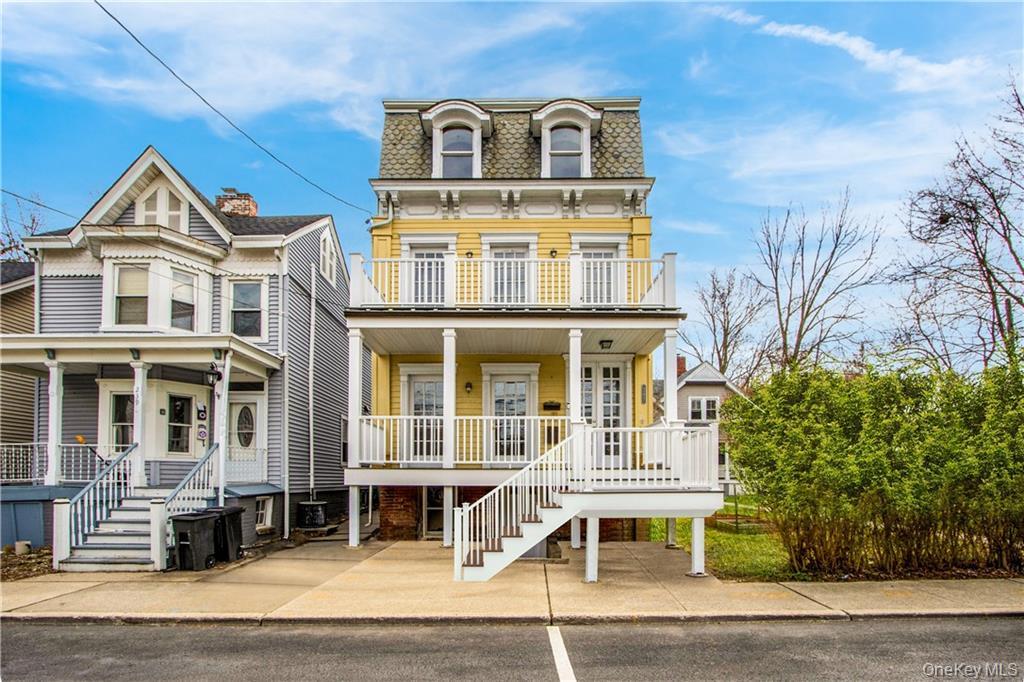 241 Main Street, Unit 2 Cornwall, NY 12518 - Photo 1 of 12 a view of a white house with large windows and a table