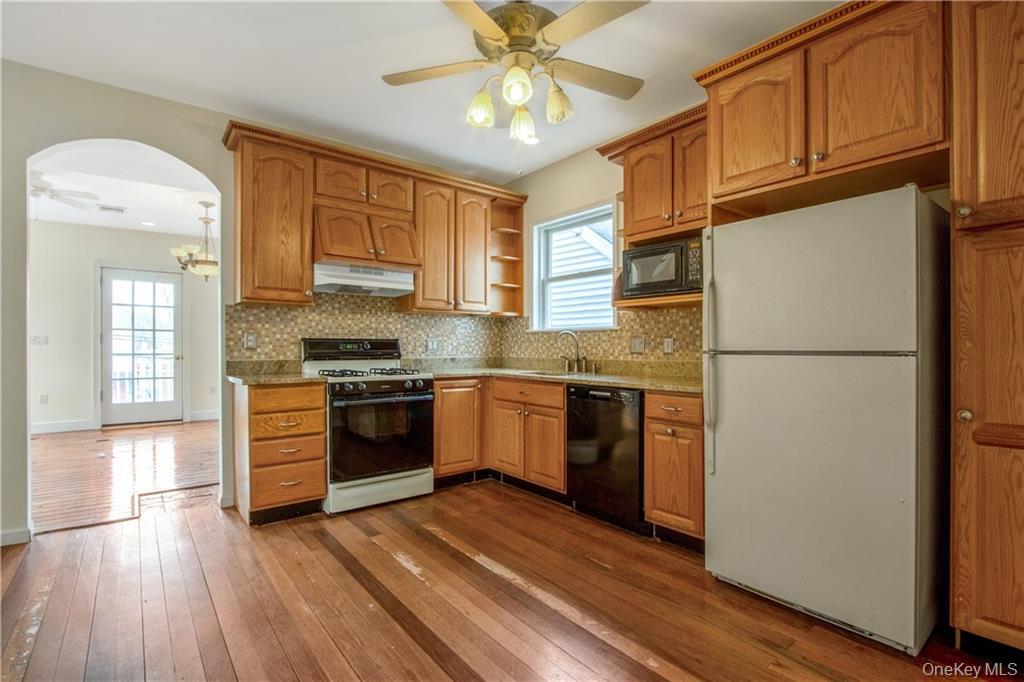 241 Main Street, Unit 2 Cornwall, NY 12518 - Photo 4 of 12 a kitchen with stainless steel appliances granite countertop a refrigerator a stove a sink and a microwave