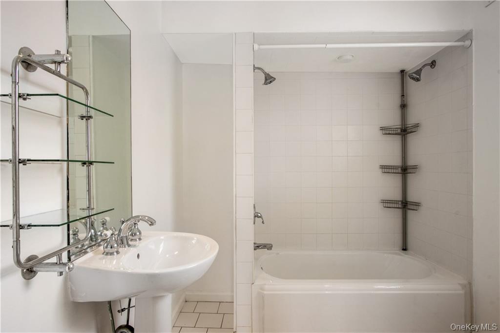 241 Main Street, Unit 2 Cornwall, NY 12518 - Photo 8 of 12 a bathroom with a sink a mirror and a bathtub