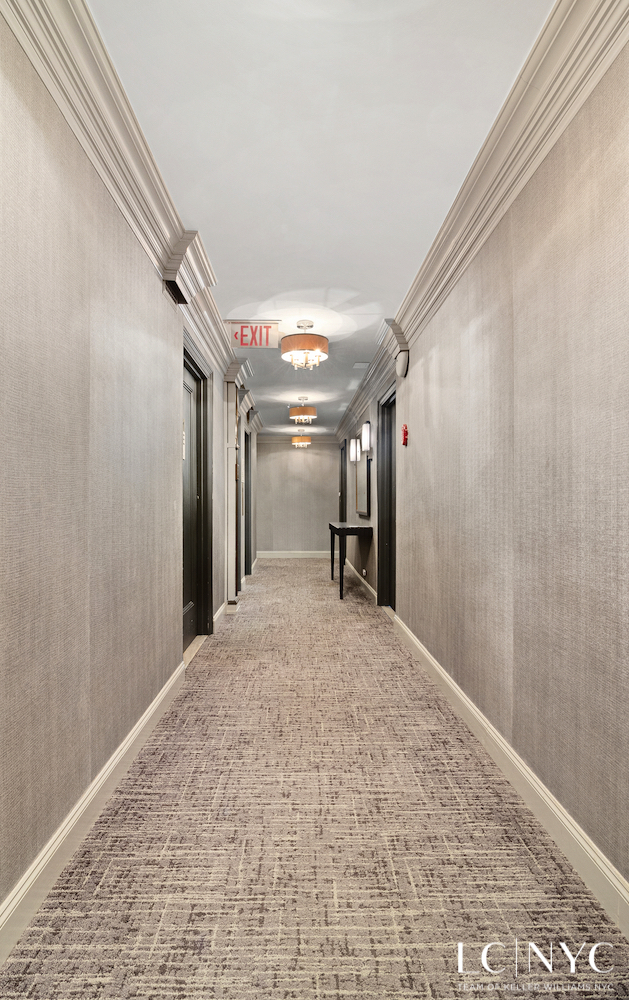 575 Park Avenue, Unit 1105 Manhattan, NY 10065 - Photo 12 of 18 a view of a hallway with wooden floor and a kitchen space