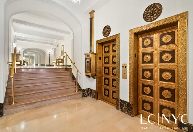 a view of a hallway with wooden floor and a kitchen space