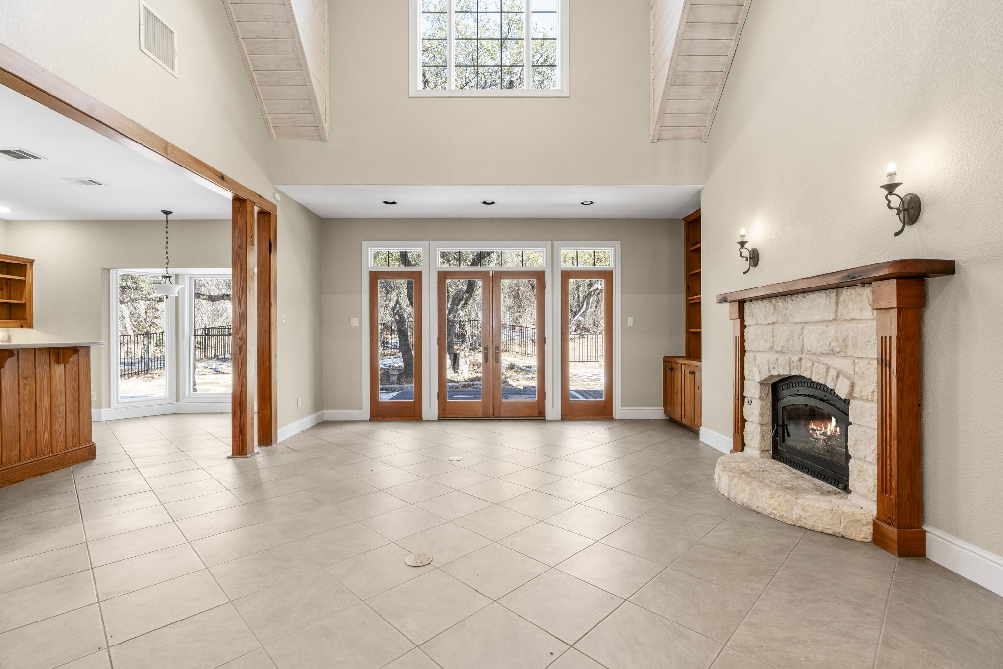 310 County Road 317 Georgetown, TX 78626 - Photo 11 of 40 Unfurnished living room with a stone fireplace, french doors, a towering ceiling, and light tile patterned floors