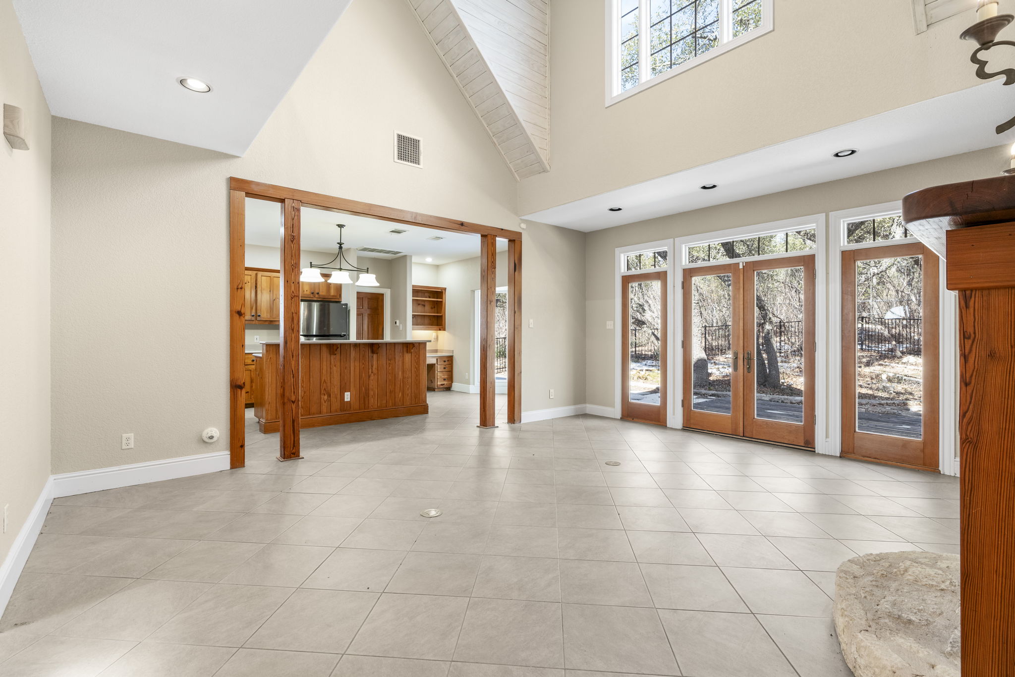310 County Road 317 Georgetown, TX 78626 - Photo 13 of 40 Unfurnished living room with french doors, healthy amount of natural light, high vaulted ceiling, recessed lighting, and light tile patterned flooring