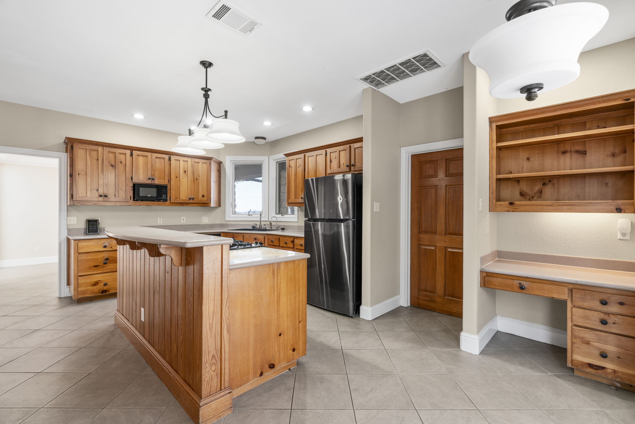 310 County Road 317 Georgetown, TX 78626 - Photo 7 of 40 Kitchen featuring light countertops, decorative light fixtures, freestanding refrigerator, light tile patterned floors, and recessed lighting