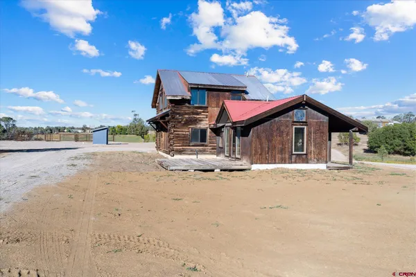 a view of a house with a patio and a yard