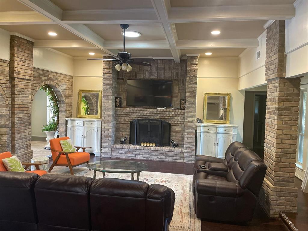 3612 Cross Bend Road Plano, TX 75023 - Photo 4 of 38 Living room with coffered ceiling, beam ceiling, ceiling fan, and a brick fireplace