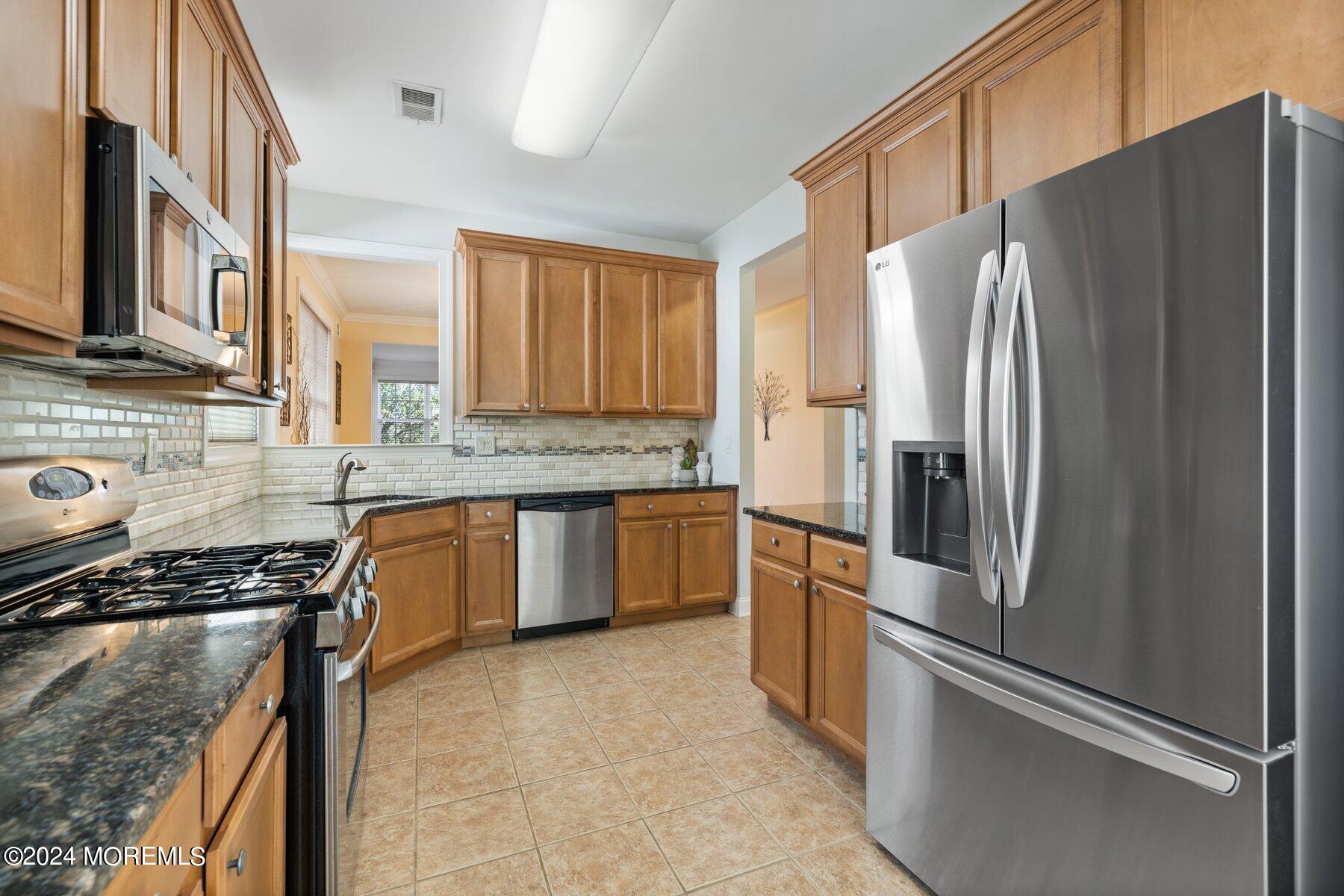 20 Silver Maple Lane Howell, NJ 07731 - Photo 4 of 35 a kitchen with stainless steel appliances granite countertop a refrigerator stove and sink
