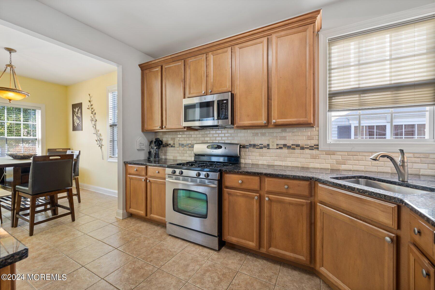 20 Silver Maple Lane Howell, NJ 07731 - Photo 6 of 35 a kitchen with stainless steel appliances granite countertop a stove a sink and a microwave