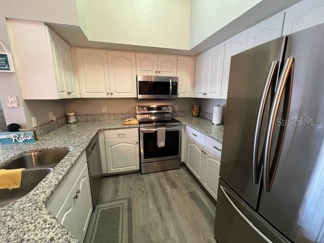 4170 Central Sarasota Parkway, Unit 428 Sarasota, FL 34238 - Photo 2 of 35 a kitchen with stainless steel appliances granite countertop a refrigerator a stove top oven a sink and dishwasher