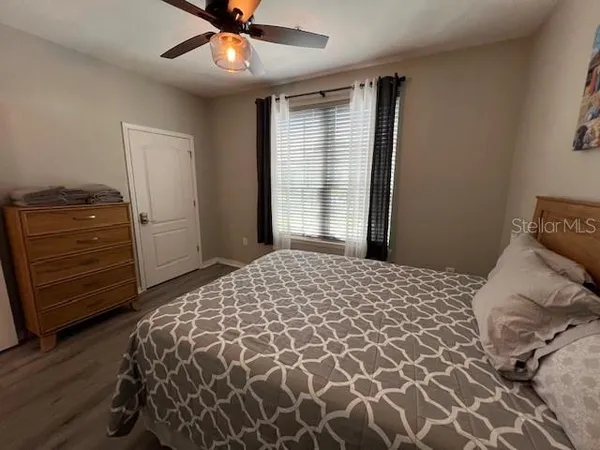 a spacious bathroom with a granite countertop sink a toilet a mirror and shower