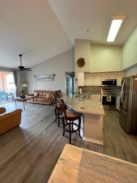 4170 Central Sarasota Parkway, Unit 428 Sarasota, FL 34238 - Photo 7 of 35 a living room with furniture and a wooden floor