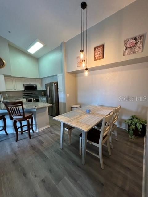 4170 Central Sarasota Parkway, Unit 428 Sarasota, FL 34238 - Photo 9 of 35 a view of a dining room with furniture and wooden floor