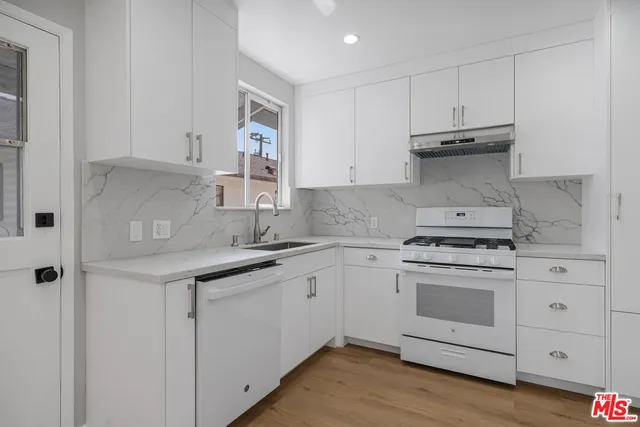 a kitchen with granite countertop white cabinets and white appliances