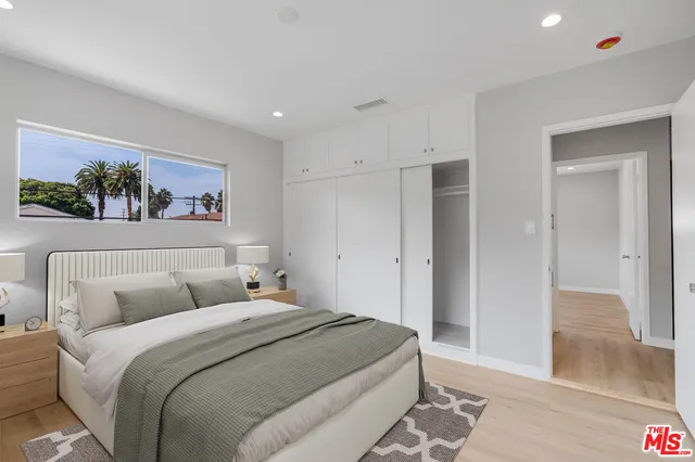 a bedroom with a large bed and a painting on the wall