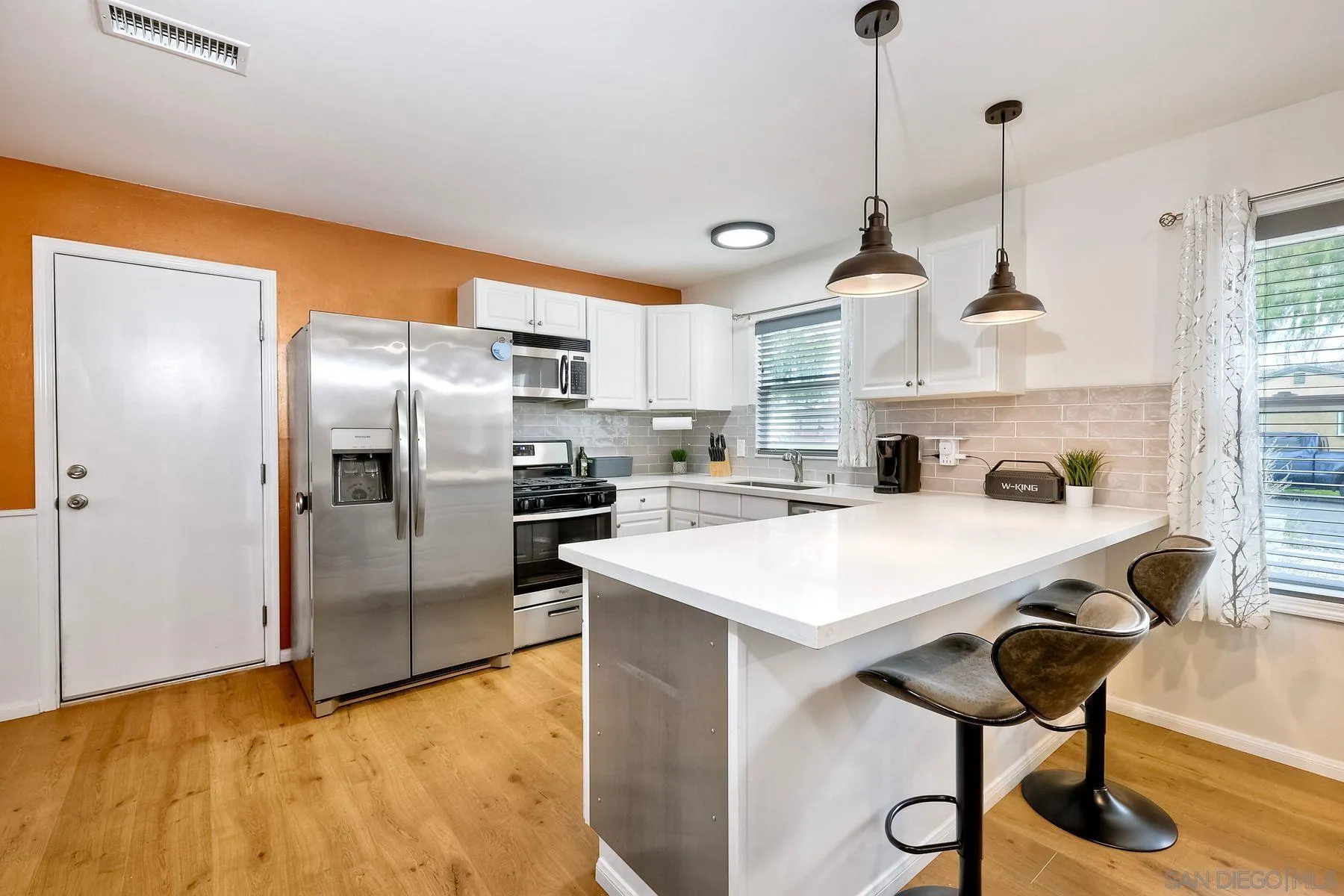 9410 Pike Road Santee, CA 92071 - Photo 8 of 25 a kitchen with stainless steel appliances granite countertop a sink a stove a refrigerator and island with wooden floor