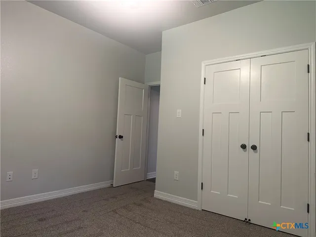 a bathroom with a toilet sink vanity and window