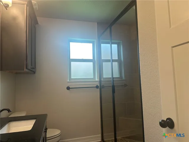 a kitchen with stainless steel appliances granite countertop a sink cabinets a stove and a refrigerator