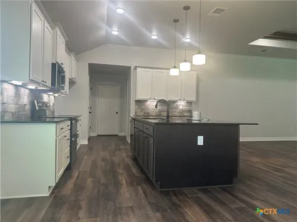 a kitchen with stainless steel appliances granite countertop a stove a sink and a refrigerator