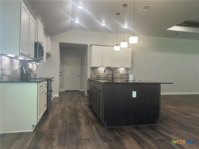 a kitchen with stainless steel appliances granite countertop a stove a sink and a refrigerator