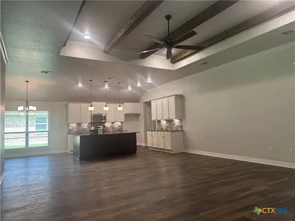 a large kitchen with a lot of cabinets and wooden floor