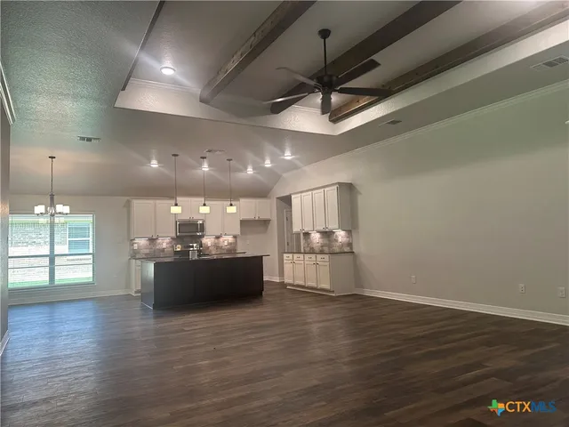 a large kitchen with a lot of cabinets and wooden floor