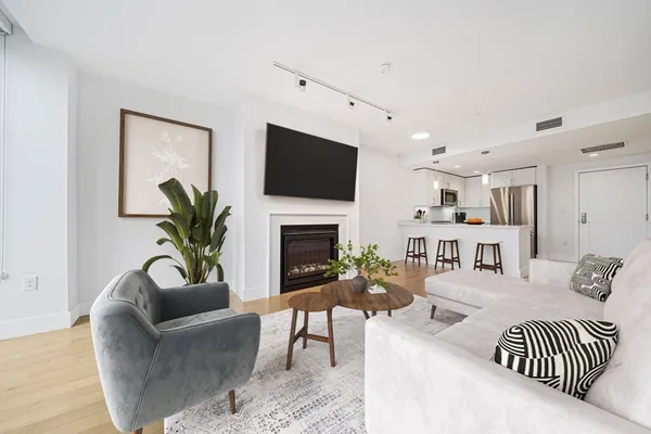 a living room with furniture a fireplace and a flat screen tv