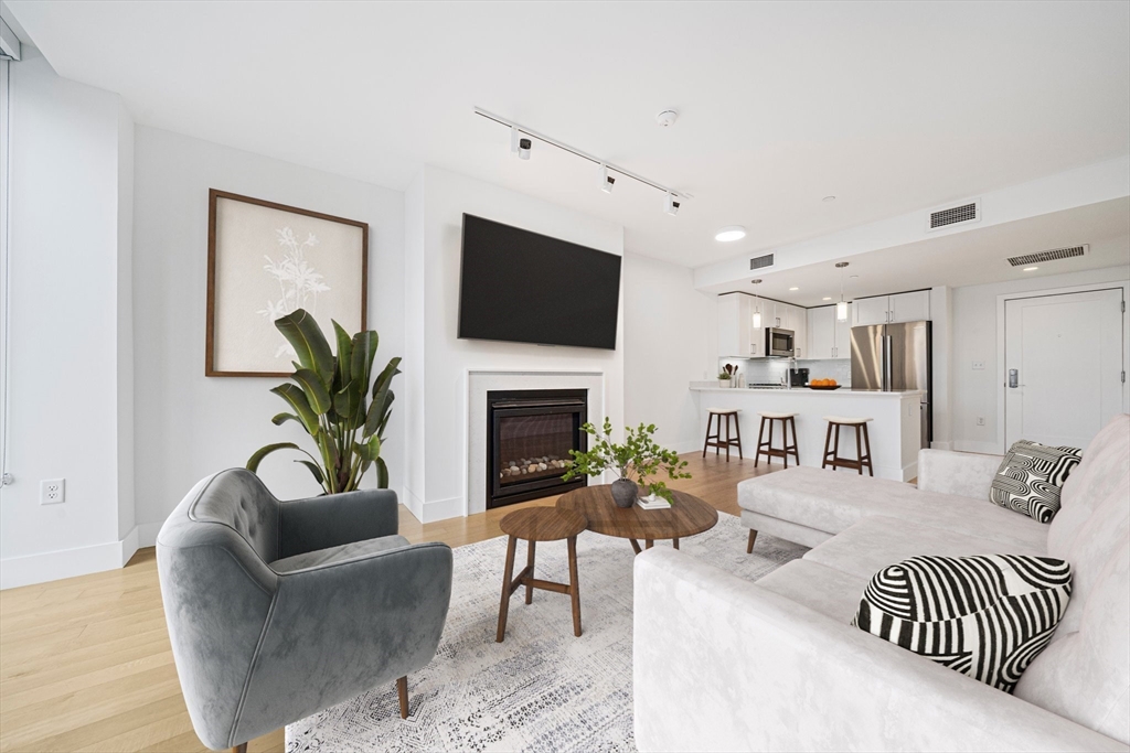 a living room with furniture a fireplace and a flat screen tv