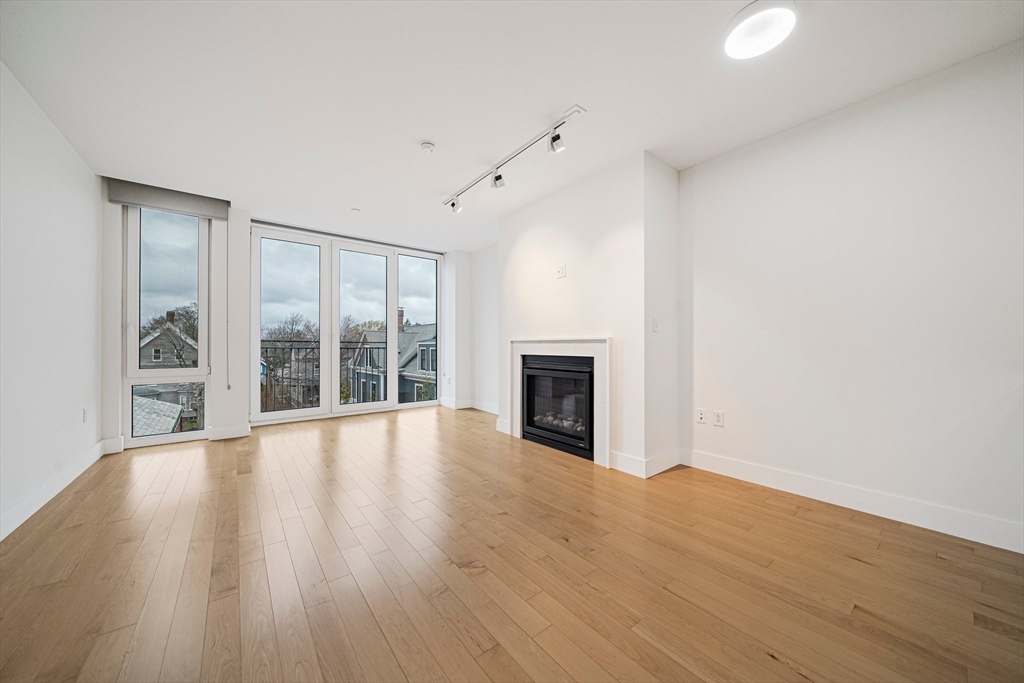 7 Beech Street, Unit 319 Cambridge, MA 02140 - Photo 8 of 27 a view of an empty room with wooden floor and a window