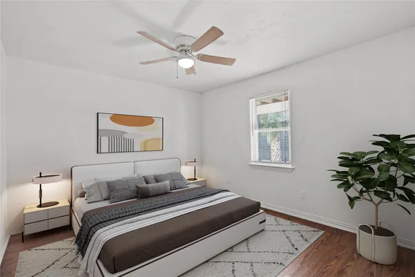 a view of an empty room with wooden floor and a ceiling fan