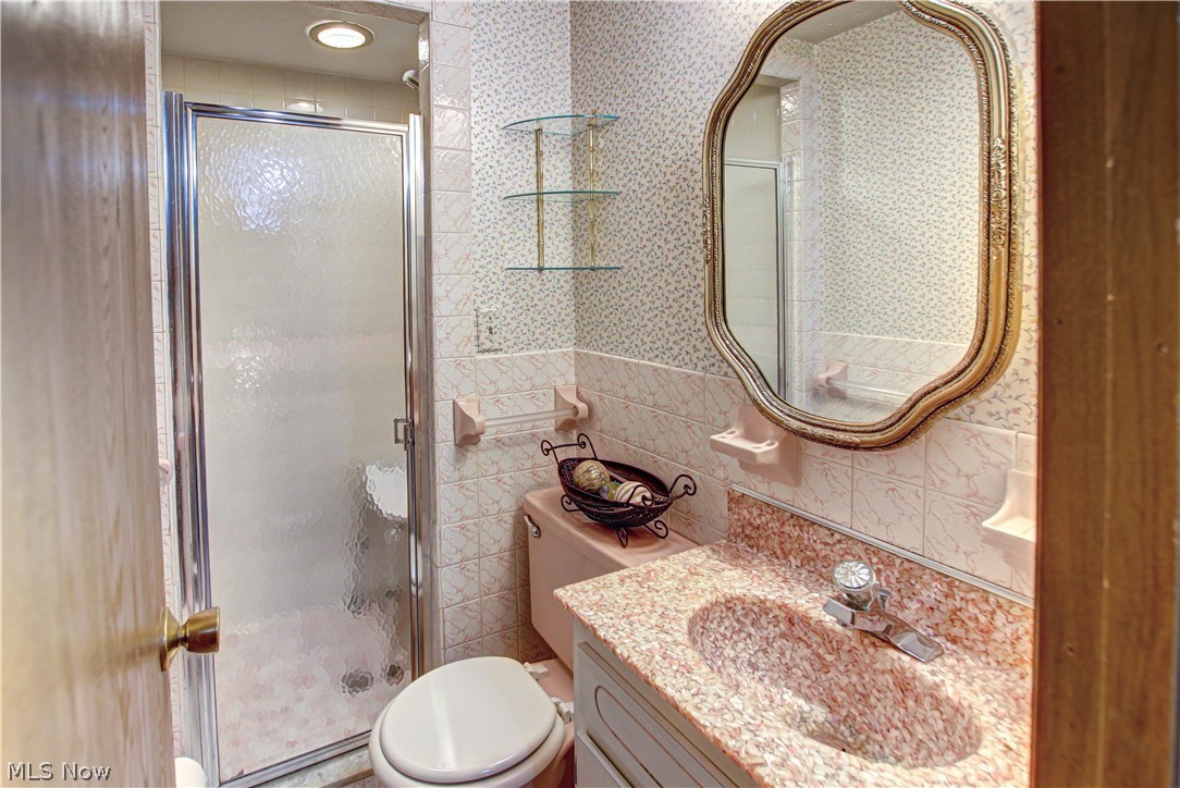 6013 Rousseau Drive Parma, OH 44129 - Photo 13 of 50 Bathroom with tile walls, backsplash, toilet, a shower with door, and large vanity