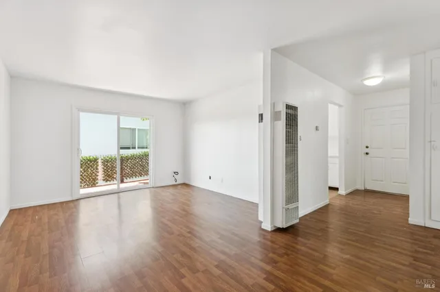 an empty room with windows and ceiling fan