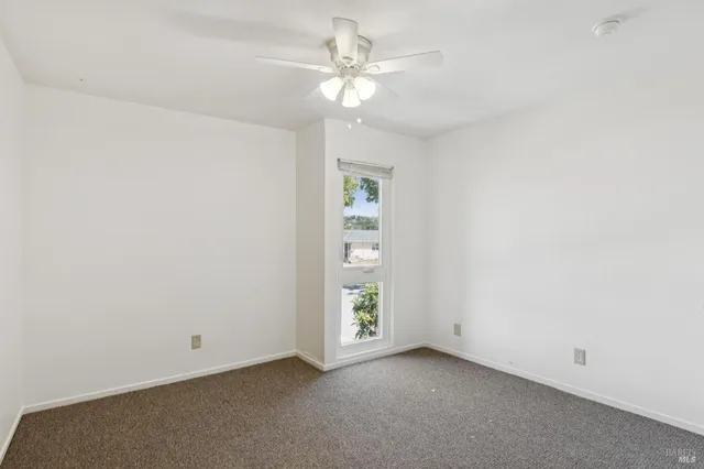 a view of a chairs and fire pit in the patio in front of a house