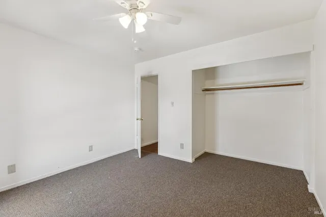 a living room with furniture a flat screen tv and a refrigerator