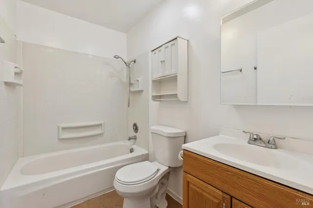 a living room with furniture and a dining table with wooden floor