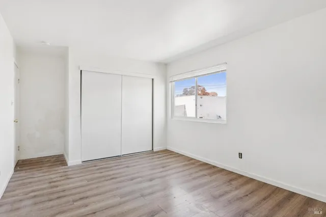 a view of a hallway with wooden floor and closet