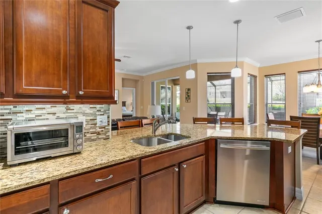 a kitchen with stainless steel appliances granite countertop a sink a stove and a wooden floors