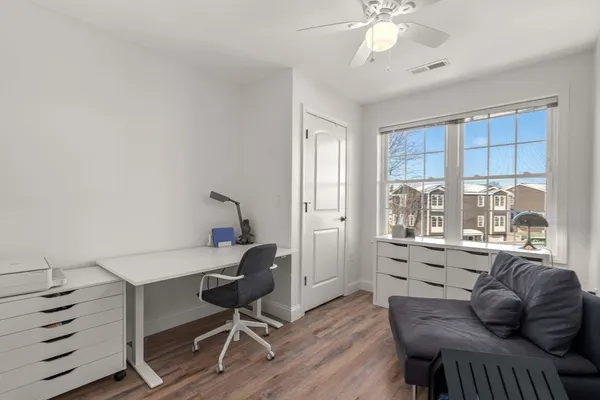 a view of a workspace with furniture and a window