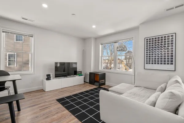 a living room with furniture and wooden floor