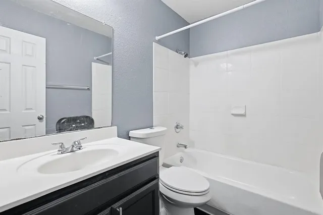 a bathroom with a sink toilet vanity and bathtub