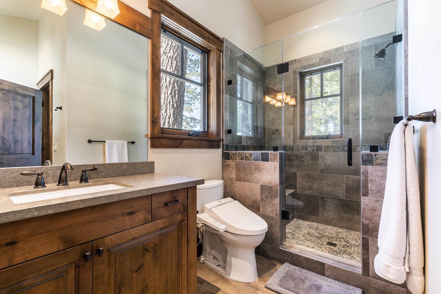11478 Henness Road Truckee, CA 96161 - Photo 13 of 21 a bathroom with a sink a toilet a mirror and a glass door shower