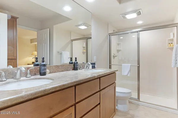 a bathroom with a granite countertop sink mirror vanity and toilet